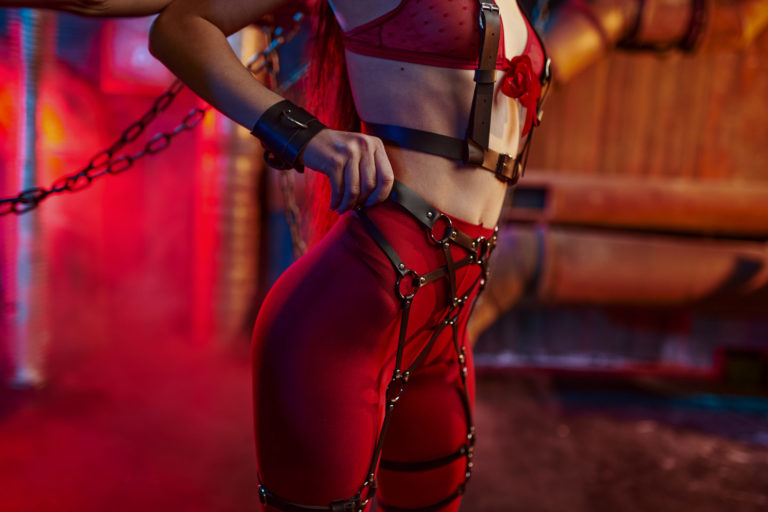 Sexy woman body in red bdsm suit chained up