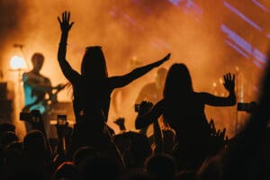 Silhouette of two woman in a crowd on a concert on a music festival