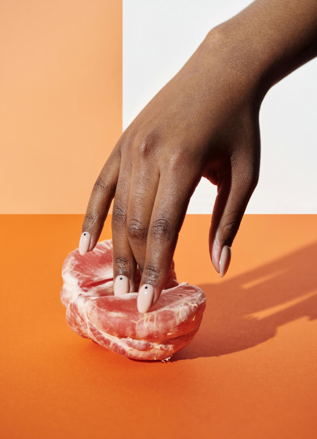 Woman sticking her fingers into a peeled orange half