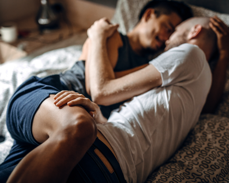 Intimate couple holding each other laying in bed