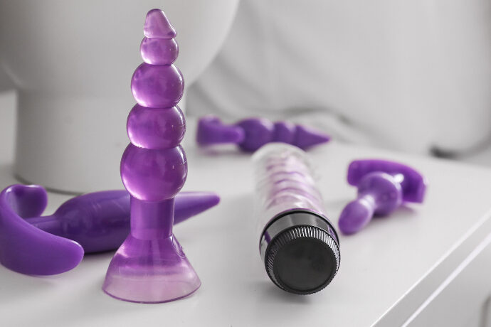 Various sex toys sitting on side table next to bed
