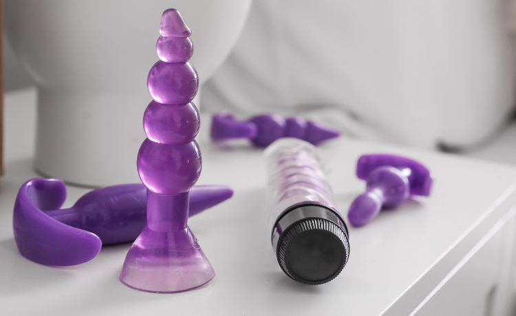 Various sex toys sitting on side table next to bed
